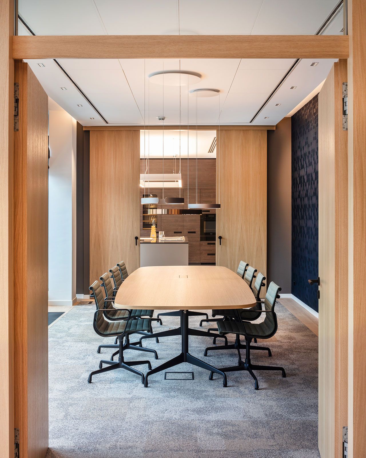 Büroetage und Firmenapartments in Hamburg - Der großzügige Tisch und die ergonomischen Konferenzstühle bieten genügend Platz für anstehende Meetings. Die eleganten Mito Leuchten von Occhio sorgen für eine optimale Ausleuchtung des Raums.