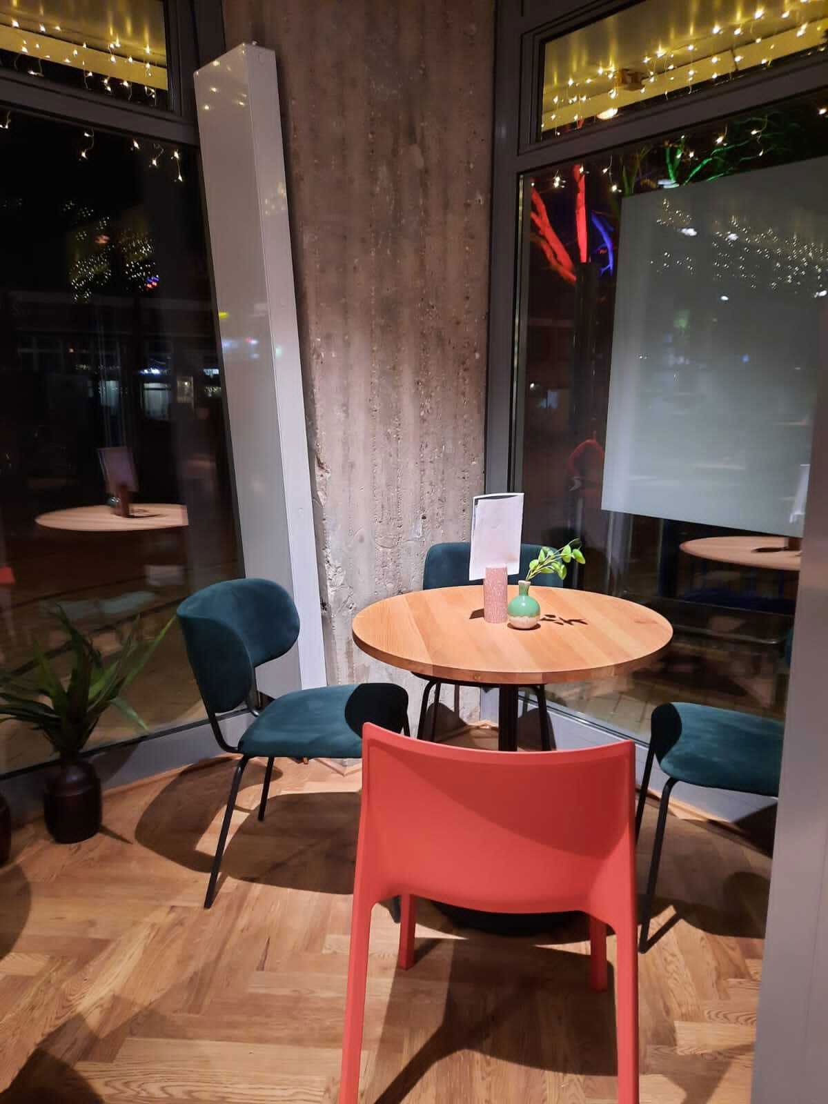 Familienrestaurant in Elmshorn - Moderner Mix: Verschiedene Stuhlmodelle in Kombination mit eichefarbenen Tischen.