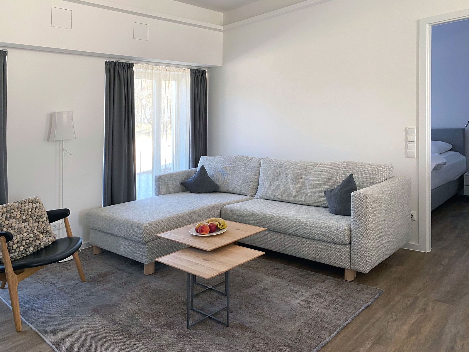 Ferienwohnungen in Prora - Vorhänge: Jab Anstoetz, Sessel: Houe, Beistelltische: Scholtissek, Sofa: Franz Fertig, Teppich: Vintage Unique, Stehleuchte: Foscarini