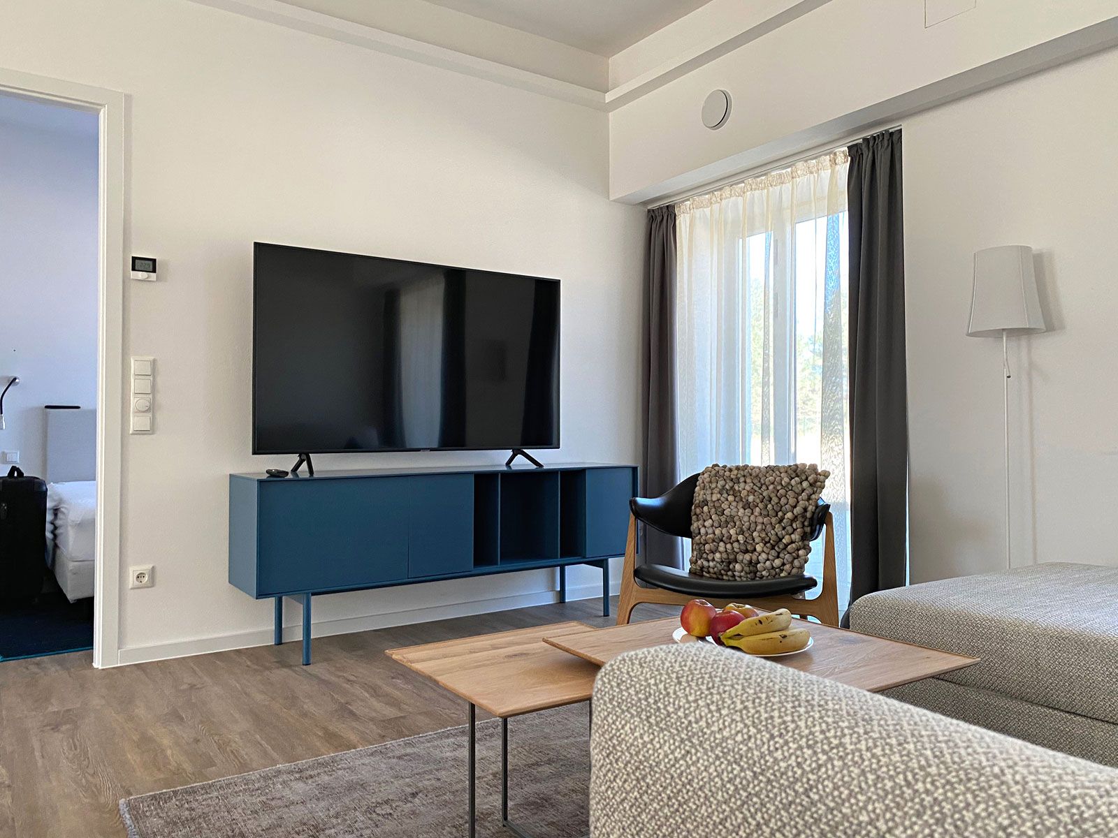 Ferienwohnungen in Prora - Vorhänge: Jab Anstoetz, Sideboard: Novamobile, Sessel: Houe, Beistelltische: Scholtissek, Stehleuchte: Foscarini