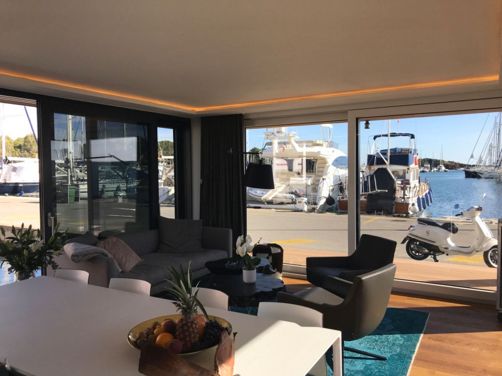Hausboot in Cannes - Blick in den Wohnbereich des Bootes: Ledersessel von Marelli, Couchtische von Scholtissek, Sofa von Wendelbo, Teppich Vintage, Esstisch und Stühle von Arper