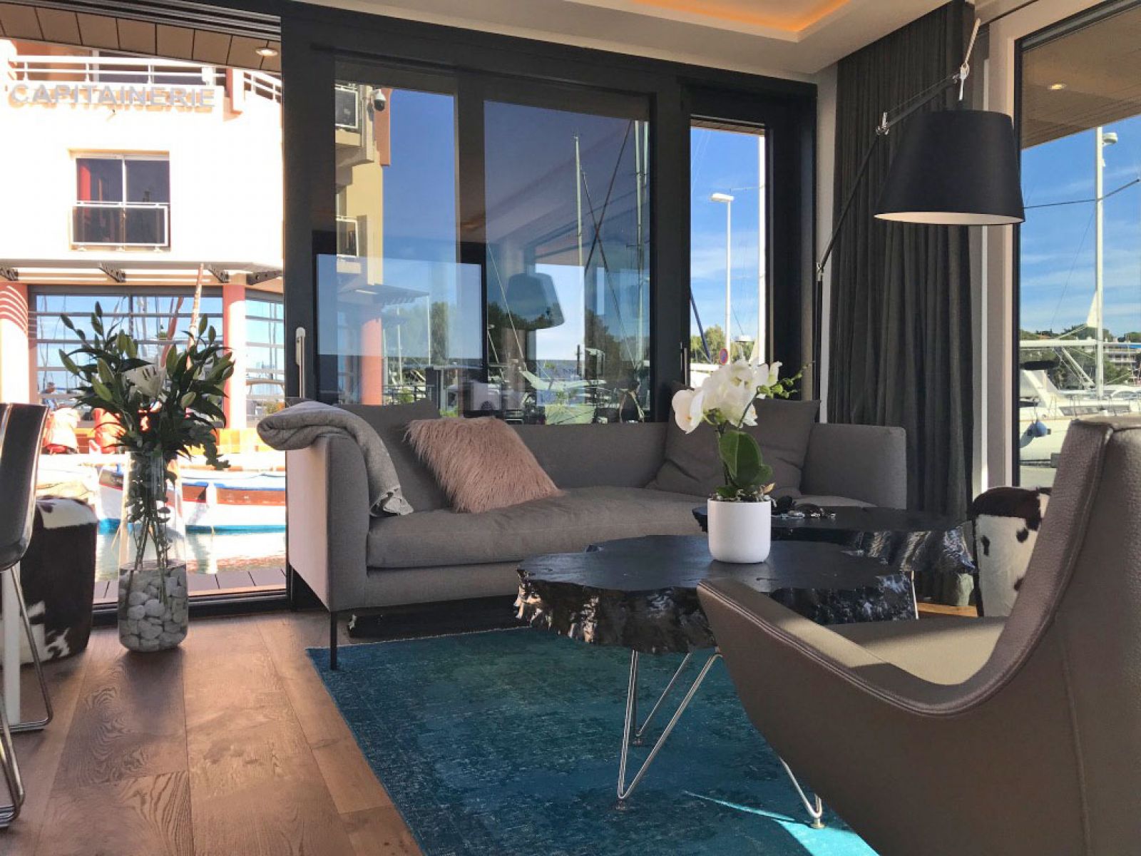 Hausboot in Cannes - Blick in den Wohnbereich des Bootes: Ledersessel von Marelli, Couchtische von Scholtissek, Sofa von Wendelbo, Teppich Vintage, Esstisch und Stühle von Arper