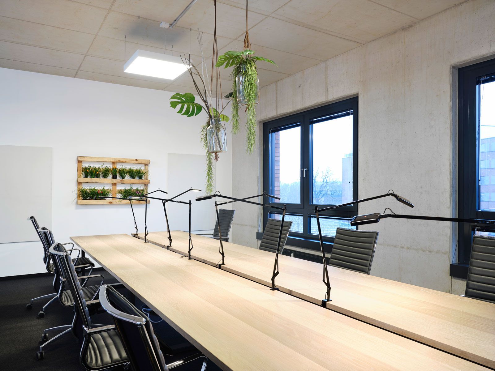 Headquarter einer Kita - Konferenztisch mit Kabelablage aus der Cramer Holzmanufaktur, Bürostühle von Alias, Klemmleuchten von Flos, Deckenleuchte von Molto Luce