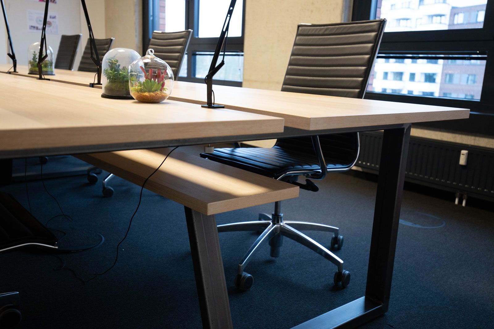 Headquarter einer Kita - Detailansicht: Konferenztisch mit Kabelablage aus der Cramer Holzmanufaktur,Bürostühle von Alias