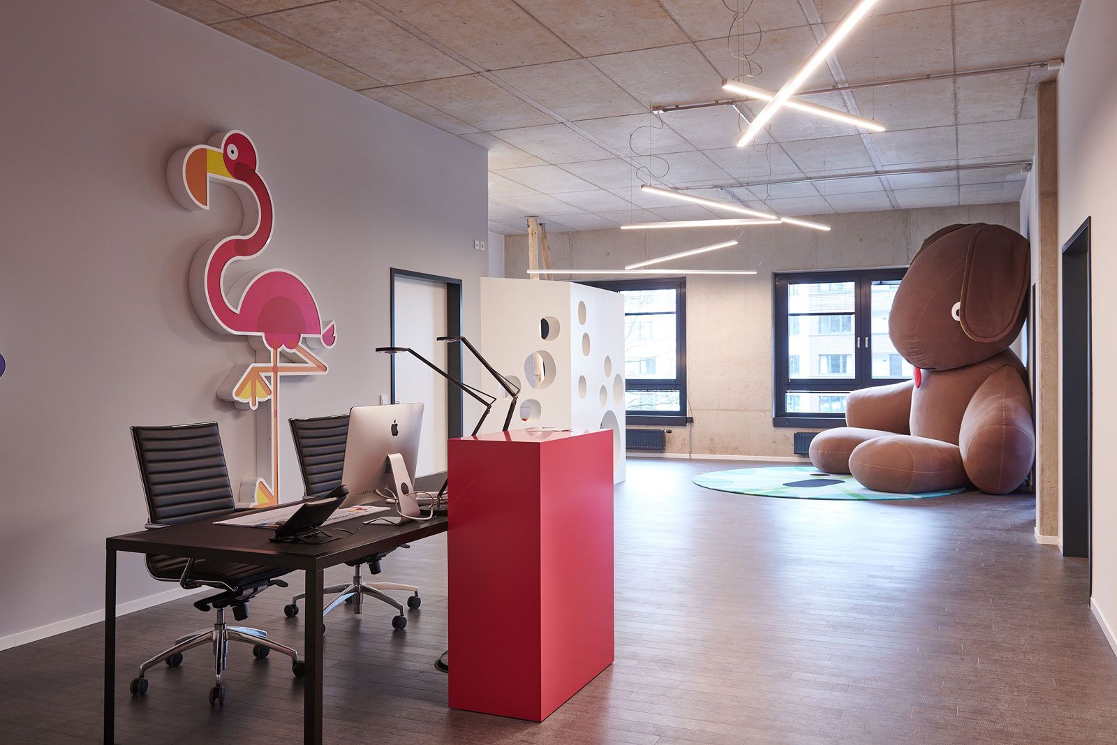 Headquarter einer Kita - Elternbereich: Bürostühle Alia von Cramer, Schreibtisch von Zeus, Schreibtischleuchten Kelvin von Flos, Tresen aus der Cramer Holzmanufaktur, Pendelleuchten von Molto Luce, Kaninchen CO9 XXL von Fatboy