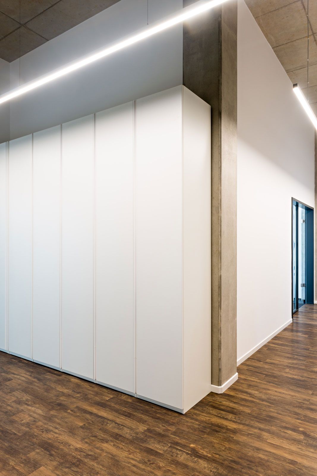 Headquarter im Industrial-Style - Nahaufnahme: Schrank aus der Cramer Holzmanufaktur, Pendelleuchte Ride von Molto Luce