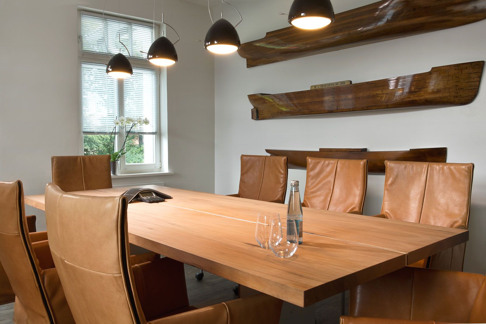 Büro mit Gästewohnung - Holztisch von Form Exclusiv, Armlehnstühle von Monte, Pendelleuchte von Grau