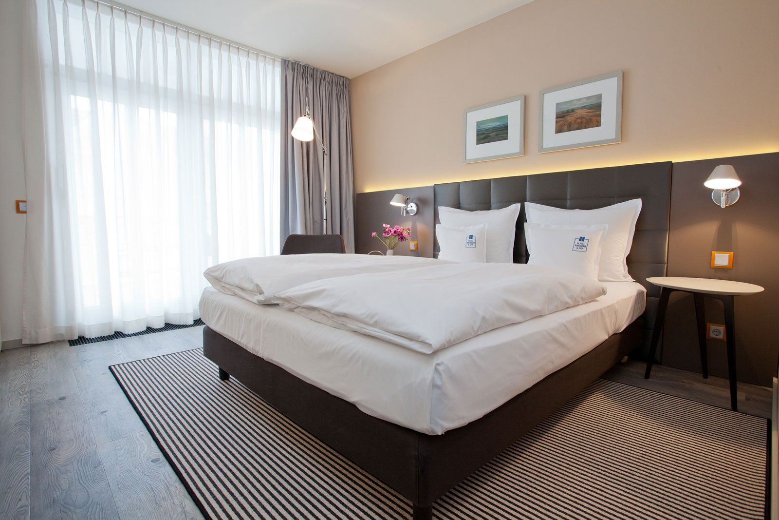 Boutique-Hotel an der Ostsee - Zimmerbeispiel: Betthaupt als Sonderanfertigung von Lema, Nachttisch Flowers von Lema, Steh- und Wandleuchte Tolomeo von Artemide, Teppich von Object Carpet