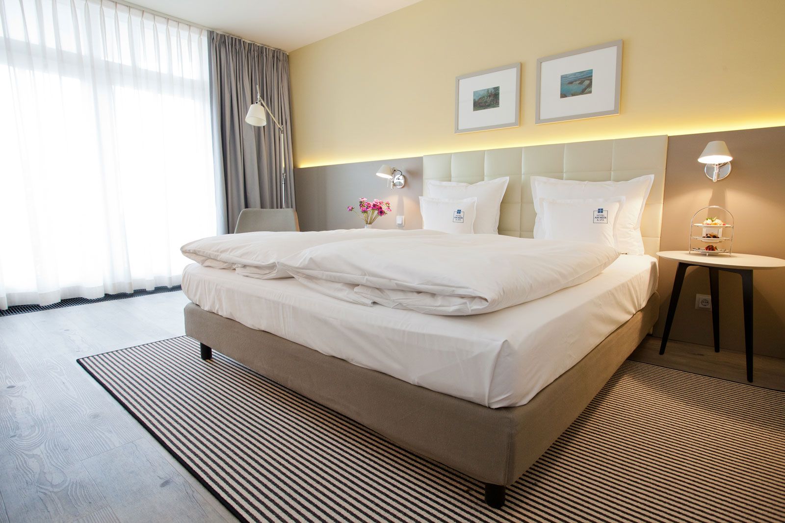 Boutique-Hotel an der Ostsee - Zimmerbeispiel: Betthaupt als Sonderanfertigung von Lema, Nachttisch Flowers von Lema, Steh- und Wandleuchte Tolomeo von Artemide, Teppich von Object Carpet