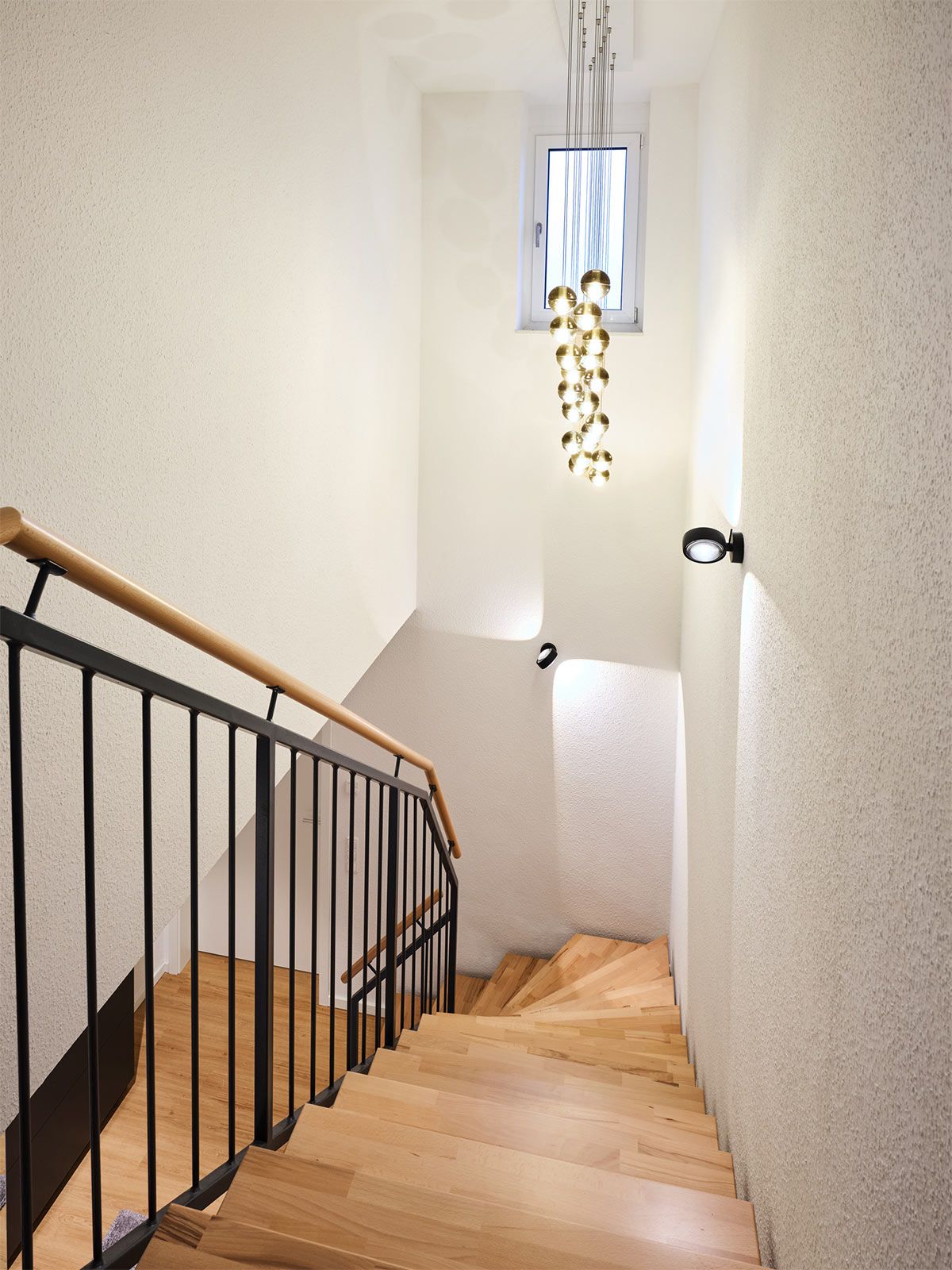 Stadtapartment in Altona - Die große Hängeleuchte mit mundgeblasenen Glaskugeln ist ein echter Blickfang im Eingangsbereich.