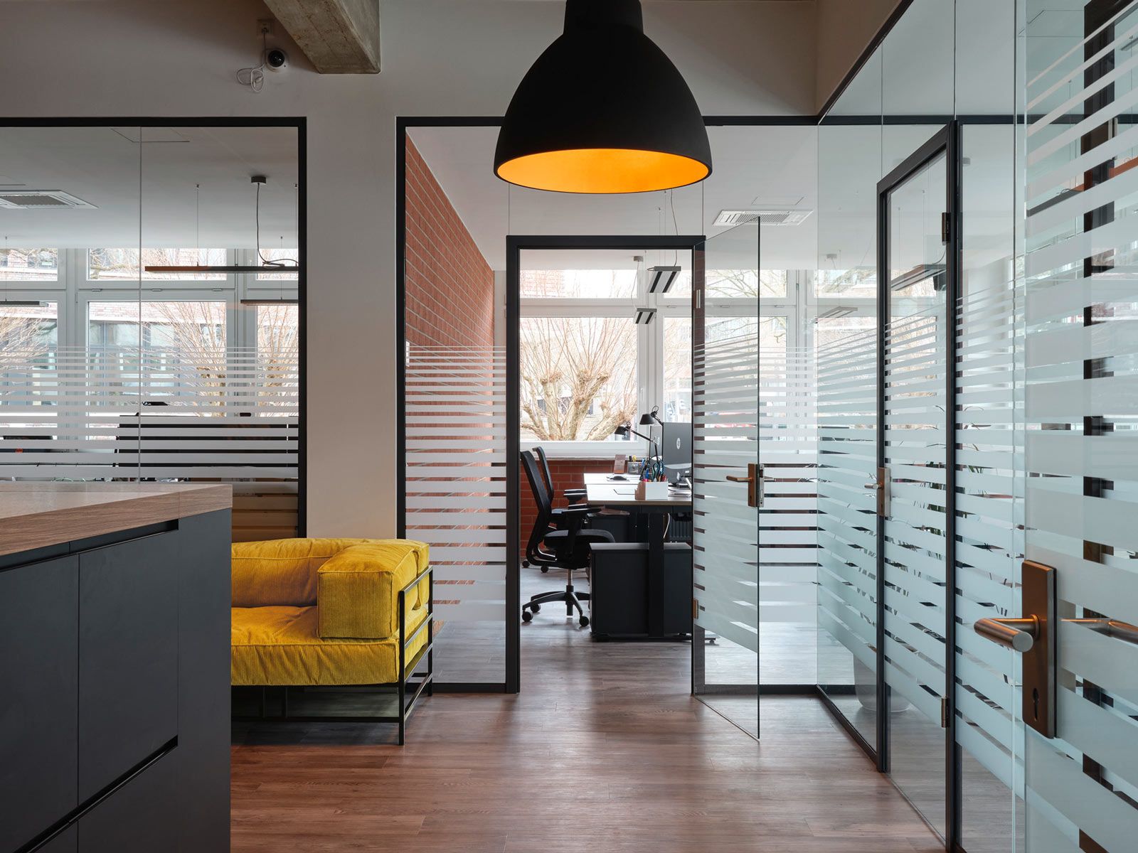 Modernes Office in Hamburg - Viel Glas und Beton. Die farbenfrohen Polstermöbel stehen hierzu in lockerem Kontrast.