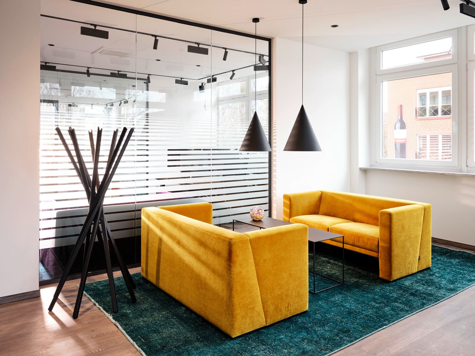 Modernes Office in Hamburg - Der Sitzbereich im Chefbüro wird durch den Teppich optisch vom Rest des Büros separiert.