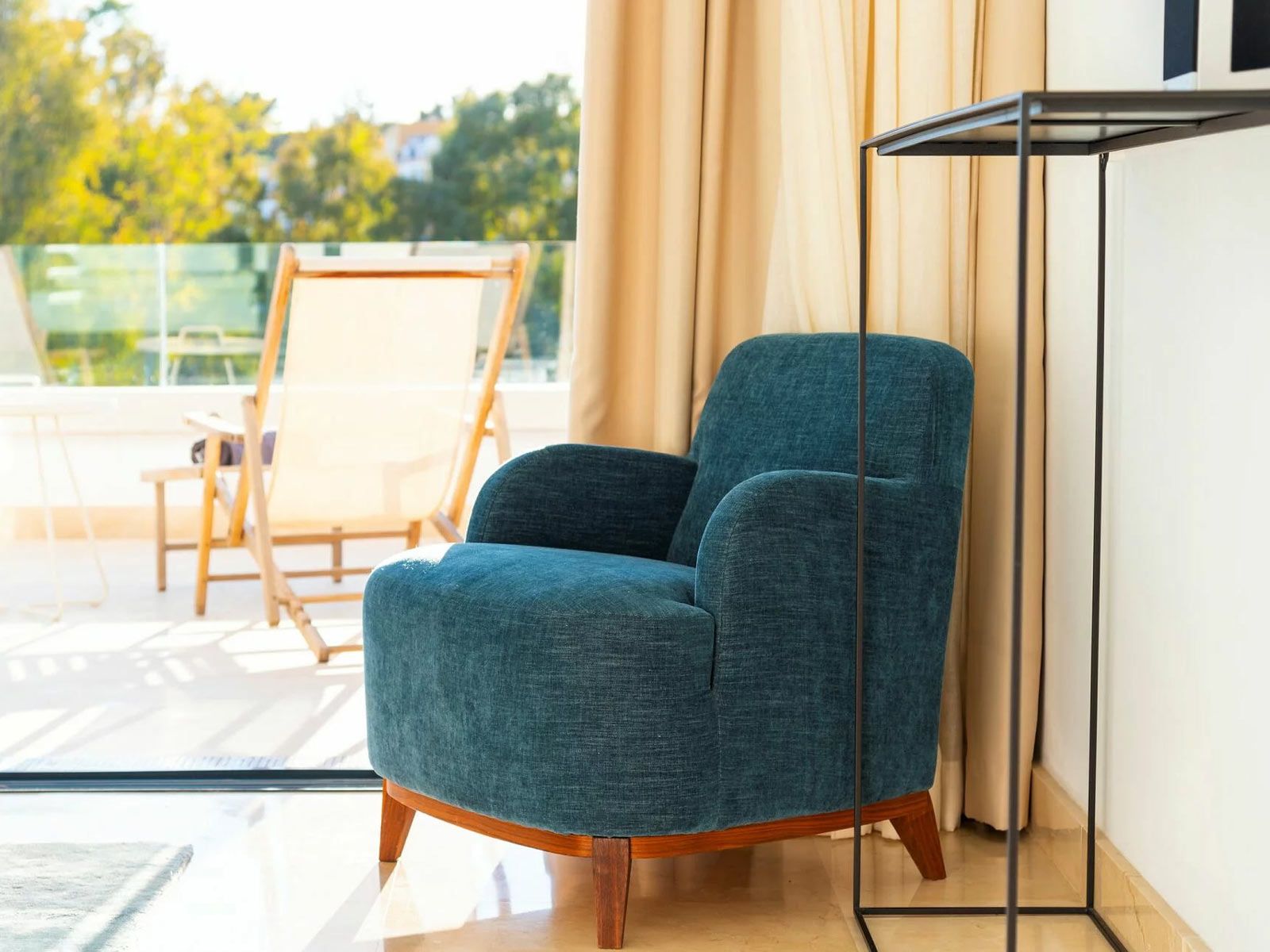Villa Senses in Marbella - Der weiche Chenille-Stoff und die geschwungenen Formen des Sessels Cavallo aus der Cramer Polstermanufaktur treffen auf Metall und Geradlinigkeit.