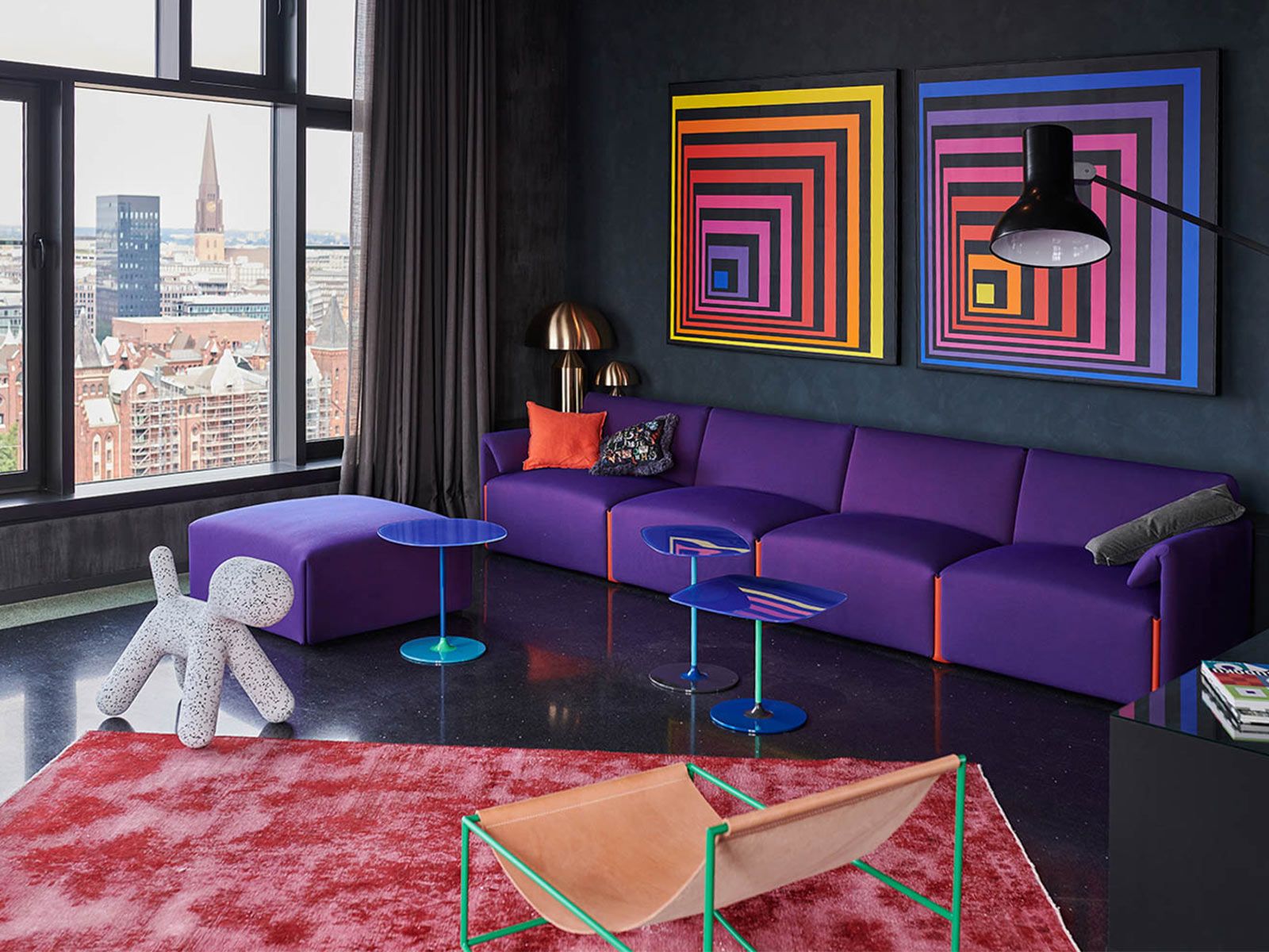 Loft in der Hafen City - Das Sofa Costume von Magis greift die Farben aus den Wandbildern auf. Der Rocking Chair von Valerie Objects wirkt mit seinem grünen Gestell als Kontrast in der Szenerie. artworks by Darko Caramello Nikolic