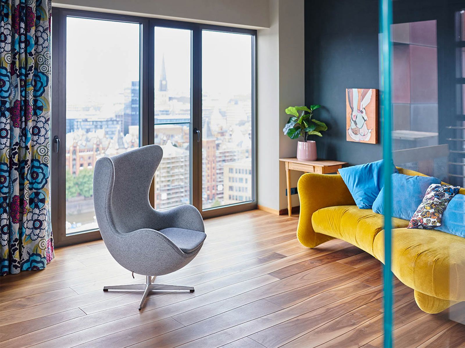 Loft in der Hafen City - Mit seinem samtigen, gelben Stoff bringt das Sofa Bongo Bay von Brühl Farbe in den Raum. Der hellgraue 