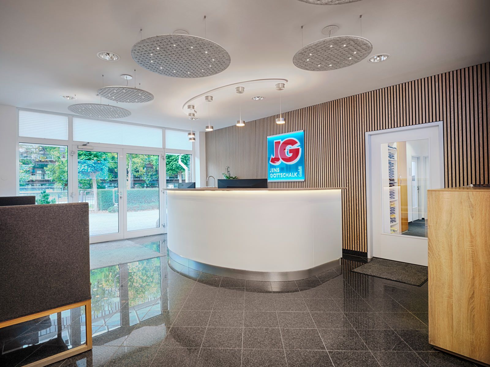 Empfangsbereich auf kleinem Raum - Durch die Rundung des Tresens werden die Laufwege auf subtile Weise betont. Zusätzlich erhält der Raum eine weiche und einladende Wirkung.