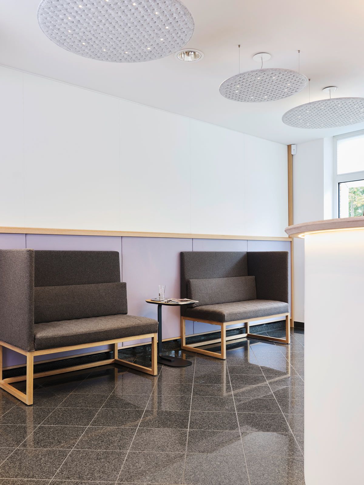 Empfangsbereich auf kleinem Raum - Auf den Belami High Bänken von Brühl nimmt man gerne kurz Platz. Der Relate Side Table von Muuto bietet passend hierzu die ideale Ablagefläche. An der Wand sorgen Flächen aus Akustikfilz für eine Reduzierung des Schalls.