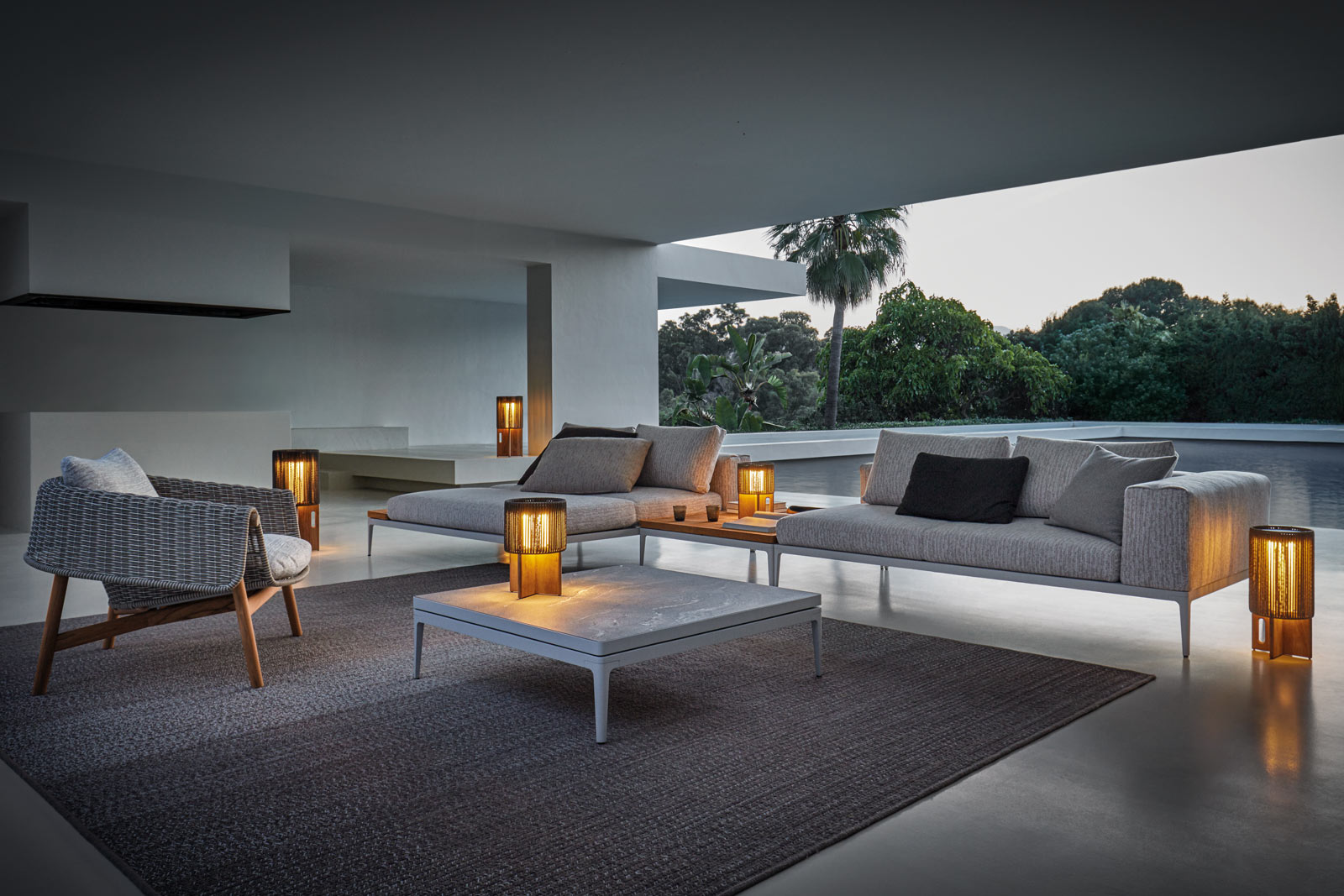 Der Wrap Lounge-Chair und die Ambient Compass Leuchten ergänzen das Grid Outdoor-Sofa perfekt.