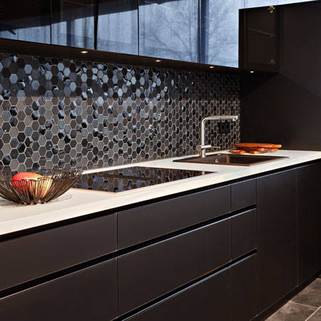Küche Culina mit schwarzer Glasfront, weißer HPL-Arbeitsplatte und Küchentresen mit Massivholzplatte aus Eiche